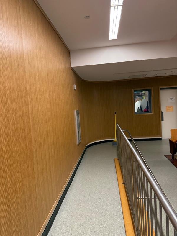 Renovated corridor with wood wall paneling, stair railing and new flooring