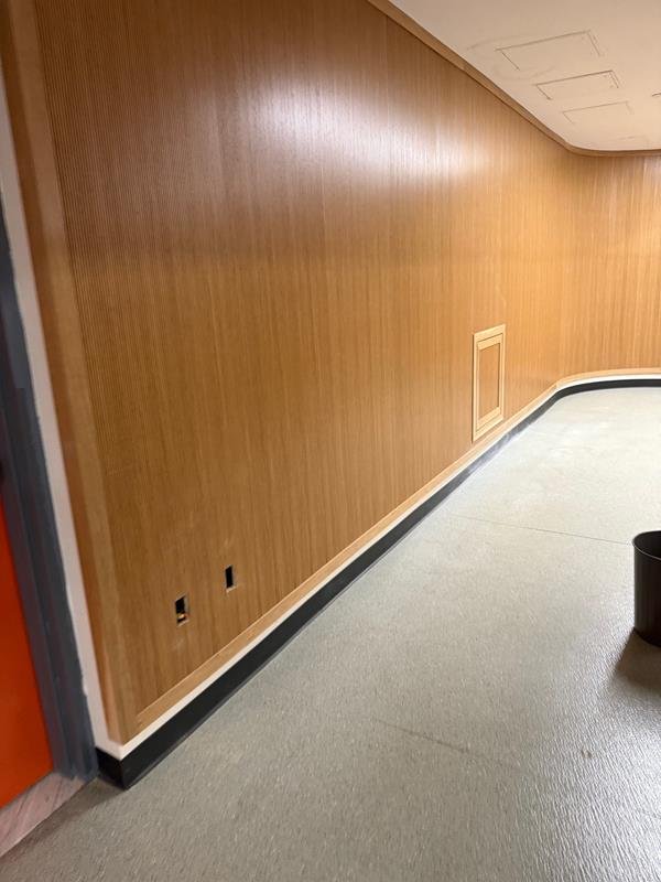 Long continuous wood-paneled corridor wall