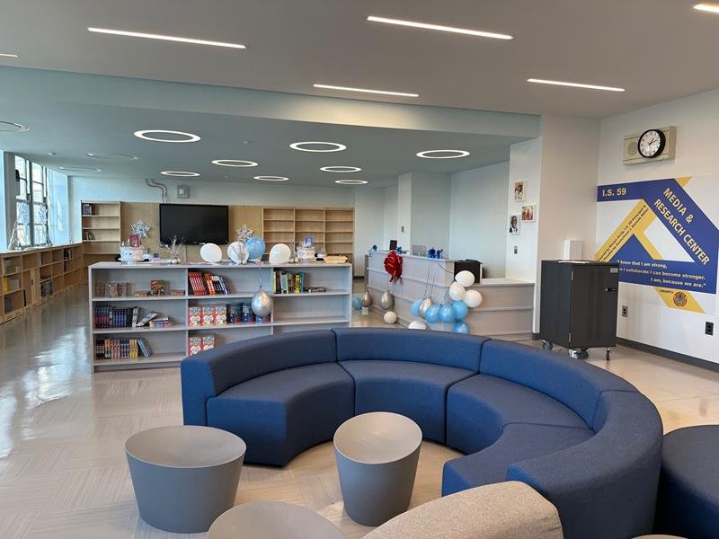 I.S. 59 media and research center with curved blue seating and ring lights