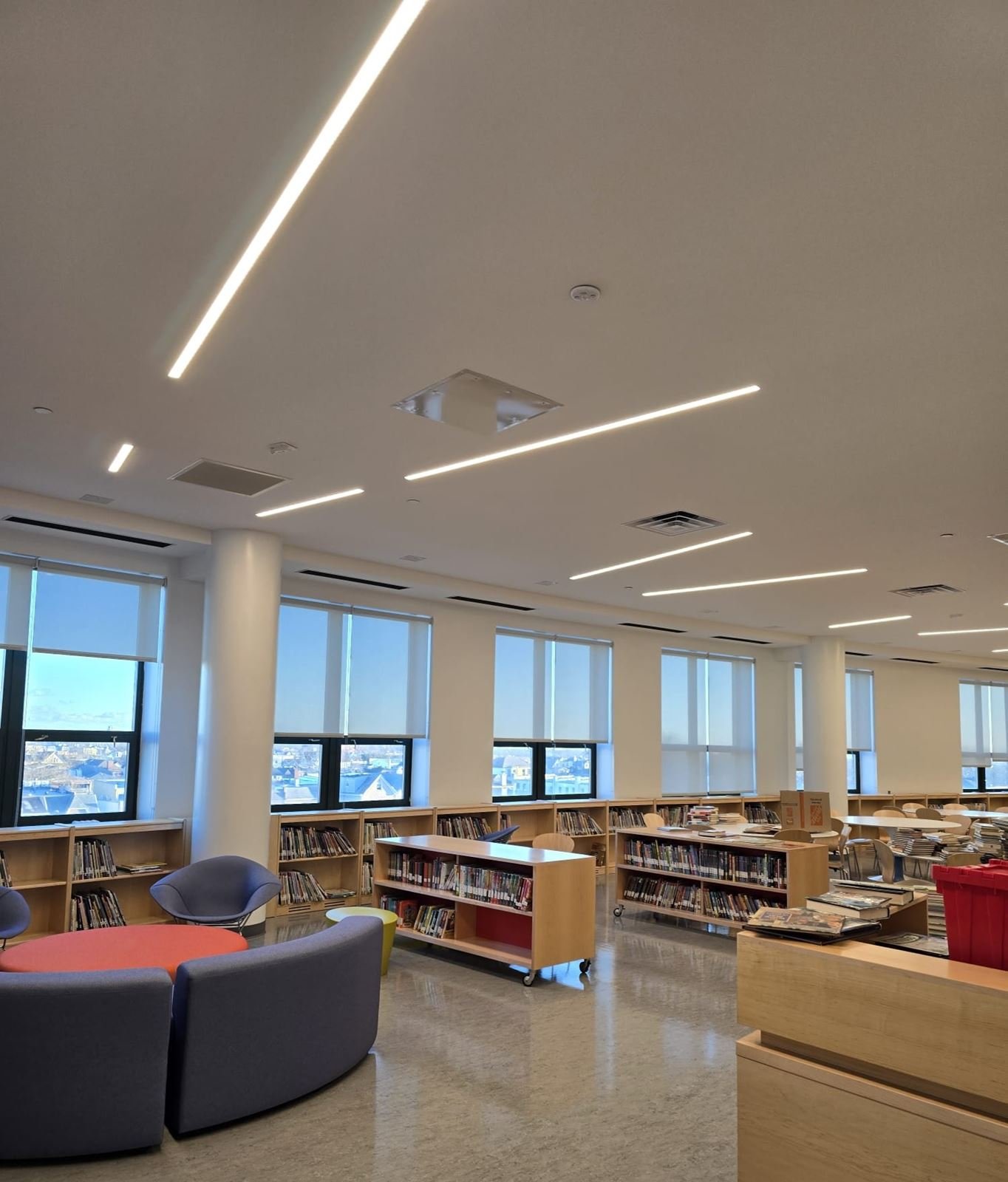 Upgraded library at P.S. 229 in Brooklyn with linear LED lighting, new shelving and soft seating